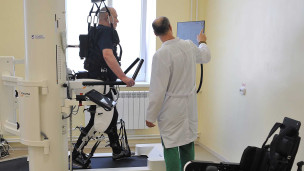 Пациент занимается на роботизированном комплексе для улучшения функций нижних конечностей