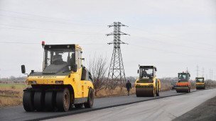 Сотрудники дорожно-строительной компании ремонтируют объездной участок дороги