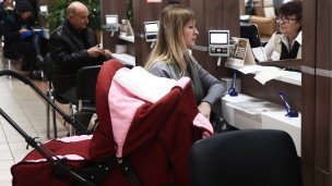 Сотрудница помогает женщине с ребенком 