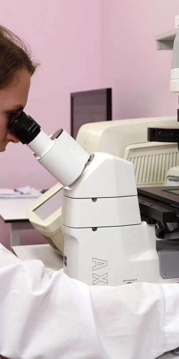 Научный сотрудник смотрит в микроскоп