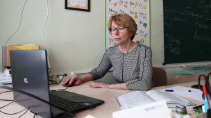 Учитель в классе за компьютером