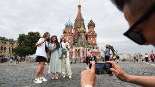 Китайские туристы в Москве на фоне Храма Василия Блаженного