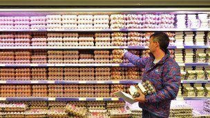 Покупатель выбирает яйца в магазине