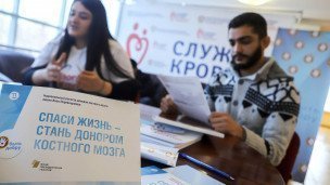 Мужчина общается с волонтером о проекте посвященном донорству костного мозга