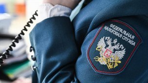 Гербовая нашивака на рукаве сотрудницы межрайонной инспекции Федеральной налоговой службы
