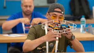 Участник СВО во время сборки дрона на чемпионате