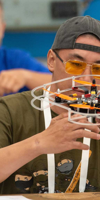 Участник СВО во время сборки дрона на чемпионате