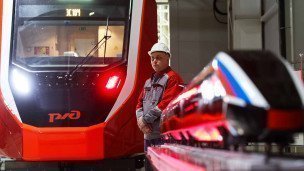 Рабочий около макета высокоскоростного поезда на заводе Уральские локомотивы