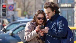 Горожане смотрят в телефон на улице 