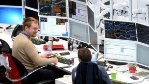 Офисные работники за экранами с графиками 
