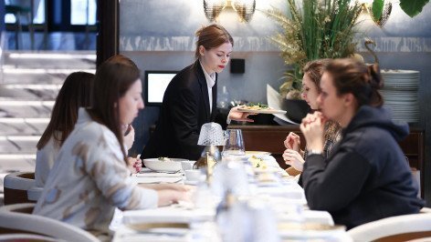 oficiantka-obsluzhivaet-posetitelej-v-restorane