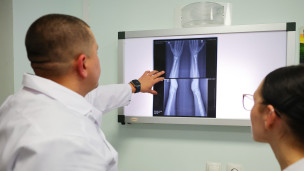 Врачи-травматологи осматривают рентгеновский снимок 