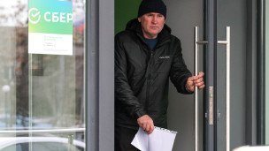 Мужчина выходит из офиса банка