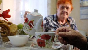 Пожилая семейная пара пьет чай дома