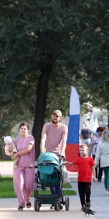 Семья гуляет в праздничный летний день в городе
