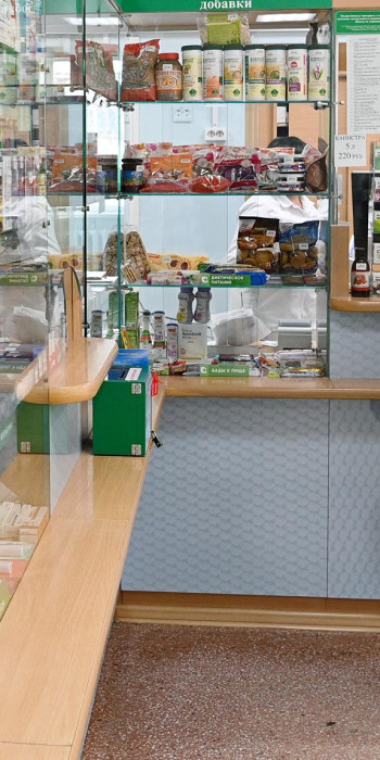 Женщина покупает лекарственные в аптеке