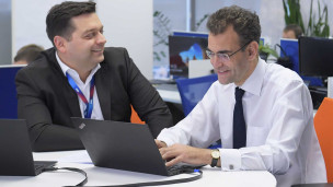 Мужчины в строгих костюмах с ноутбуком 