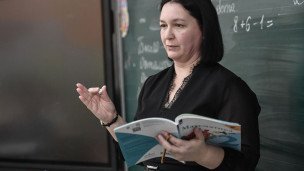 Учительница математики  во время урока в средней общеобразовательной школе