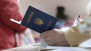Женщина держит паспорт гражданина Украины 