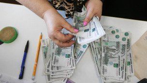 Женщина пересчитывает деньги перед выдачи