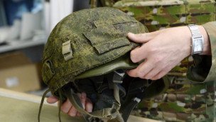 Крупный план каска в руках военного