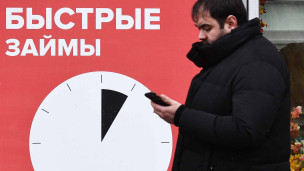 мужчина рядом с вывеской быстрые займы