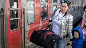 Мать с ребенком с багажом на железнодорожном вокзале