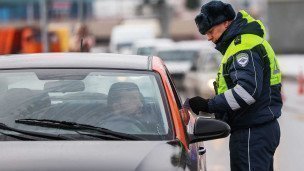 Сотрудник ДПС проверяет документы у водителя
