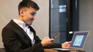 Мужчина в костюме с ноутбуком и телефоном