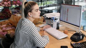 Девушка за компьютером в цветочном магазине