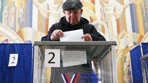 Мужчина голосует на выборах президента России