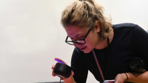 Девушка пользуется умной колонкой 