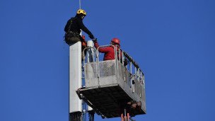 Рабочие монтируют базовую станцию сотовой связи
