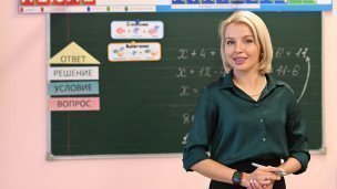 Классная руководительница начальных классов  во время урока у доски