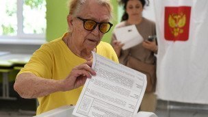 Женщина голосует на избирательном участке