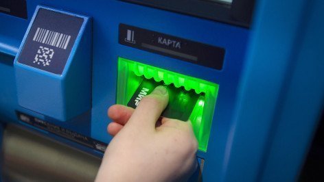 Посетитель с банковской картой МИР у банкомата