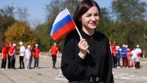Молодая девушка с флажком в руках