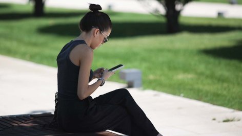 Девушка с телефоном в парке 