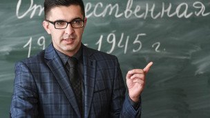 Преподаватель истории указывает на доску 