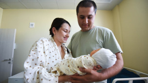 Молодые родители с новорожденным ребенком 