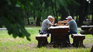Мужчины играют в шахматы в парке 