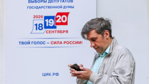 Мужчина с телефоном на избирательном участке 