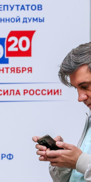 Мужчина с телефоном на избирательном участке 