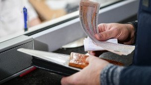 Билеты на пассажирский поезд в руках мужчины на железнодорожном вокзале