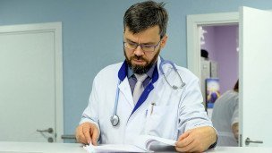Врач читает историю болезни пациента