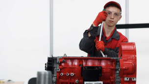 Молодой сотрудник собирает двигатель