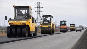 Сотрудники дорожно-строительной компании ремонтируют участок дороги