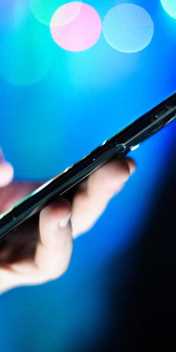 Мужчина держит в руках мобильный телефон