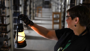 Женщина с керосиновой лампой в темноте