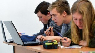 Студент сидит за компьютером и внимательно смотрит на экран